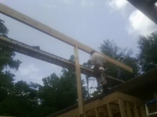 Carpenter setting a ridge beam over a new addition frame — Ice Dam Removal by Roofing Brothers in Rock Hall