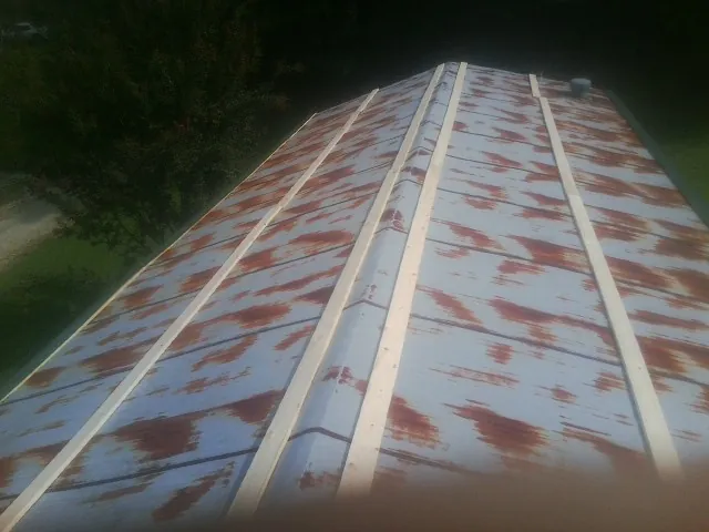 Rusted metal roof panels with new wood purlins before replacement — Storm Damage Roof Repair in Rock Hall by Roofing Brothers