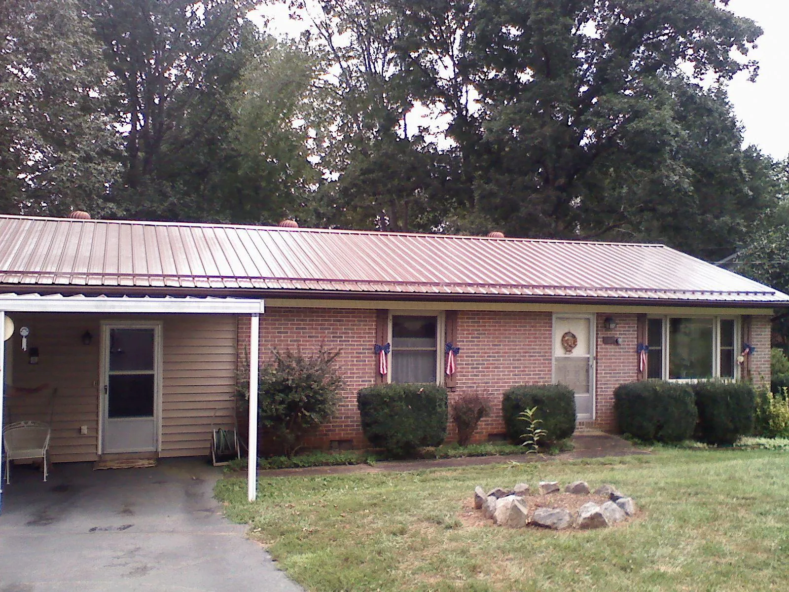 Bronze metal roof and carport on a brick ranch home — Roof Repair work by our crew in Rock Hall